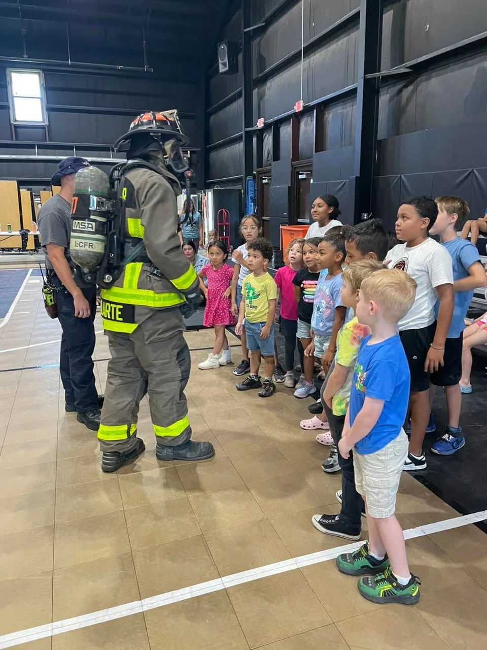 Students learning alongside a firefighter